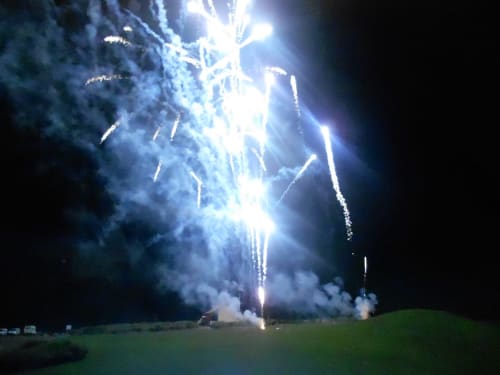 Feu d'artifice au-dessus de la plage de Biscarrosse la nuit avec prairie verte et ciel obscur