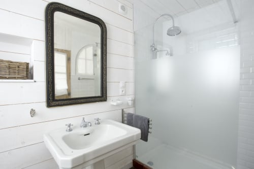 Modernes Badezimmer mit weißen Metrofliesen, verziertem Spiegel und begehbarer Dusche im Cottage Les Filles du Bord de Mer