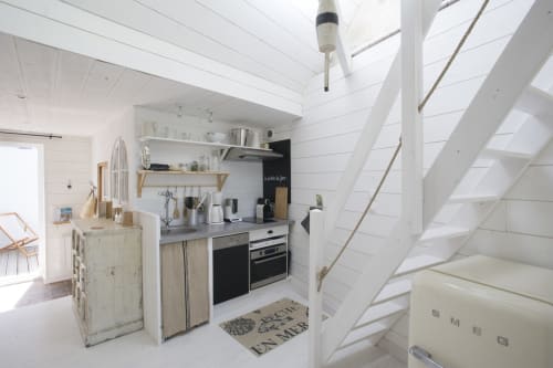 Kompakte weiße Küche in La Cabane des Pêcheurs mit modernen Geräten und Treppe in Port-en-Bessin