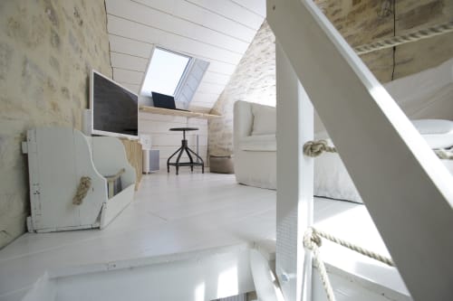 Helles Dachzimmer im Cottage Les Filles du Bord de Mer mit Dachfenster, weißem Mobiliar und Hafenblick