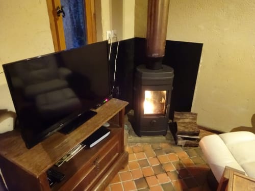 Poele a bois et TV ecran plat.