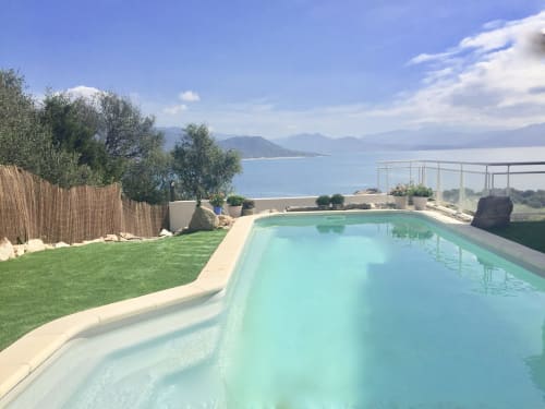 Casa Felice villa heated pool with sea view over Porto Pollo, Corsica, featuring manicured lawn and Mediterranean coastline