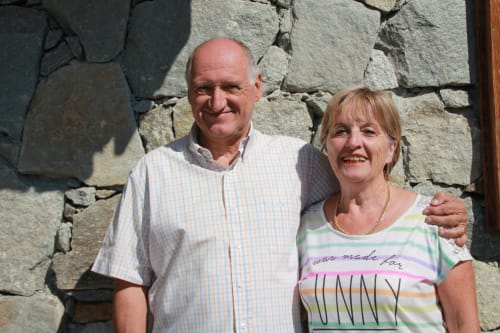 Stel lachend voor Chalet La Louvière B&B in Fontcouverte, La Toussuire, Frankrijk tegen stenen muur