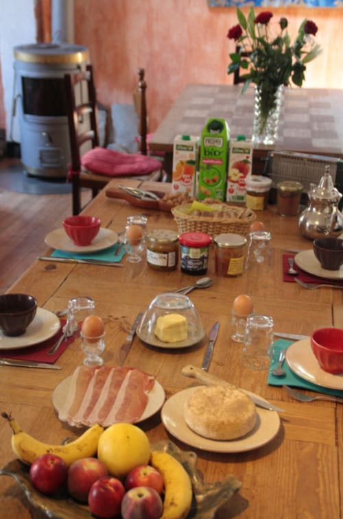 Table de petit-déjeuner à la Guesthouse La Petite étoile à Saint-Dalmas-le-Selvage avec fruits frais, pâtisseries et produits locaux