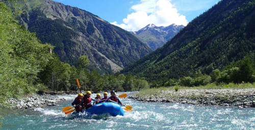 Groupe en rafting sur rivière turquoise entourée de montagnes forestières près de Mercantour, France