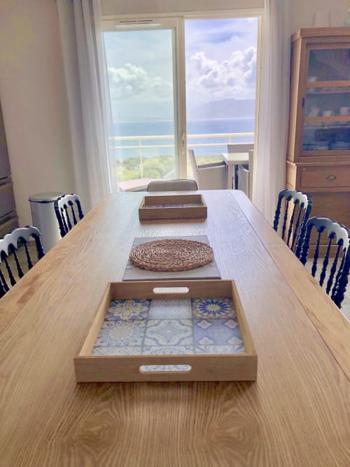 Dining room at Villas Marincelu with sea view, wooden table, decorative trays, and French Riviera coastal vista through glass