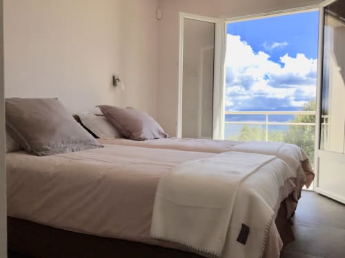 Bright bedroom with sea view at Casa Serena villa in Serra di Ferro, Corsica, featuring comfortable bed and direct terrace