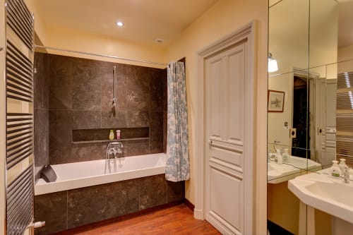 Salle de bains luxueuse au Château d'Alexis de Tocqueville avec marbre brun, baignoire îlot et équipements modernes