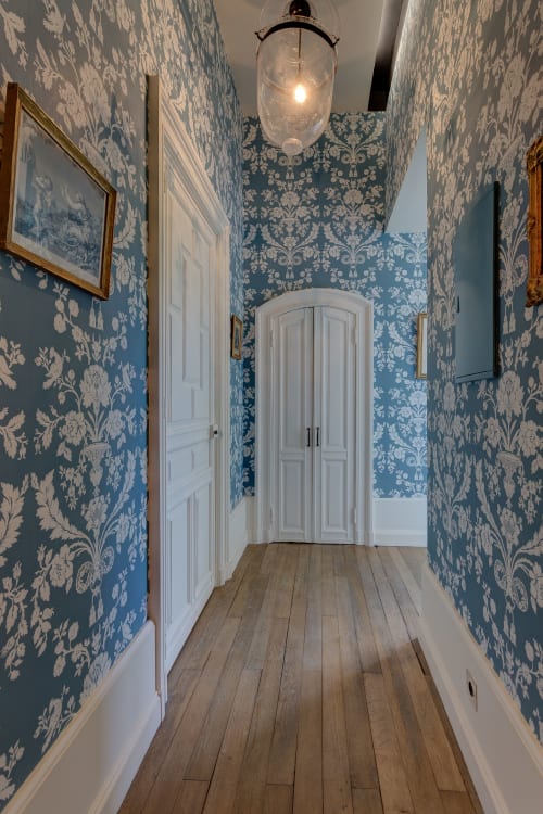 Elegant hallway with blue damask wallpaper at Château d'Alexis de Tocqueville B&B in Normandy