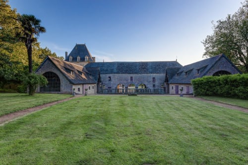 Château d'Alexis de Tocqueville, a historic stone manor with mansard roof and manicured grounds in Tocqueville, France.