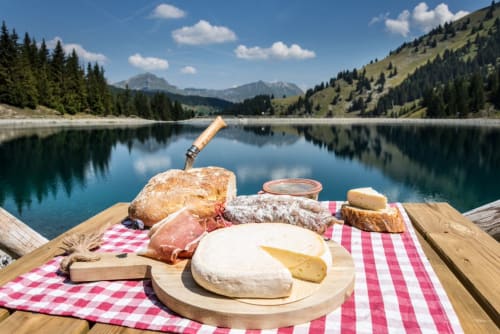 Pique-nique alpin au bord du lac avec fromage, charcuterie et pain à La Petite étoile D'hôtes En Mercantour