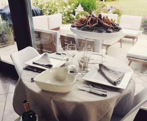 Élégante mise de table à La Cour d'Hortense avec table ronde, couverts, vins et vue sur le jardin à Sailly-Flibeaucourt.