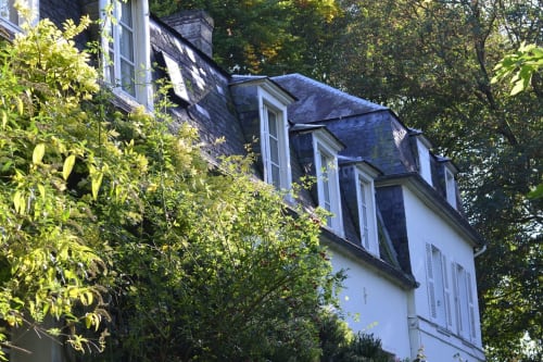 La Tour Blanche, gîte avec toit mansardé et lucarnes, nichée parmi les arbres à Forest-Montiers
