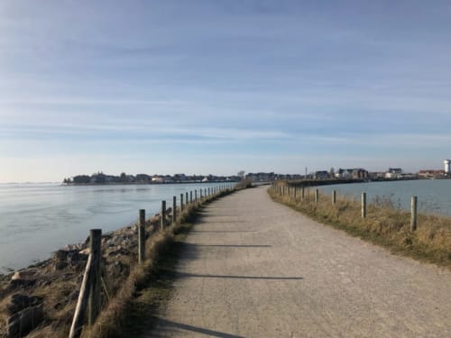 Sentier pittoresque au bord de l'eau avec clôtures en bois le long du bassin de chasse du Crotoy, France près du gîte La Tour Blanche