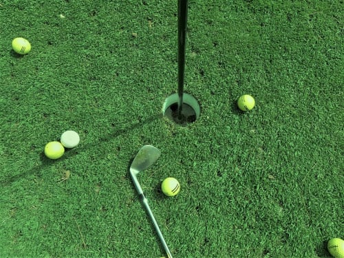 Mini-golf à La Tour Blanche avec balles et putter sur le green à Forest-Montiers