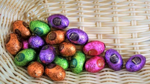 Chocolats colorés enrobés de papier brillant dans un panier en osier à La Tour Blanche, gîte de Forest-Montiers