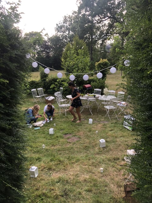 Réception EVJF en jardin à La Tour Blanche B&B à Forest-Montiers avec chaises blanches, guirlandes lumineuses et invités qui discutent