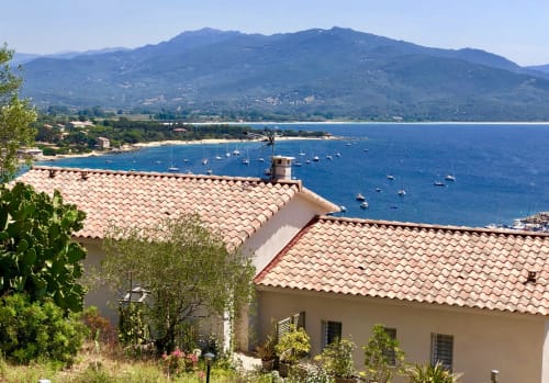 Casa Felice villa with terracotta roof overlooking Porto Pollo bay, Corsica, with sailboats and mountains