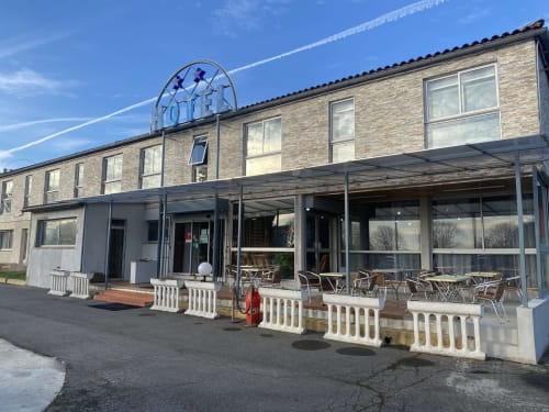 Hotel Rocade a Pamiers, França amb façana de rajola, terrassa coberta, places d'assecador exterior i entrada moderna