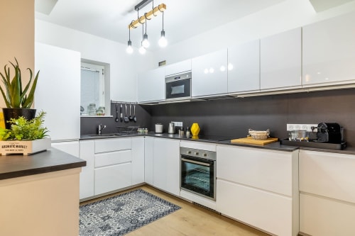 Cuisine moderne blanche avec plan de travail noir à l'Hôtel Au Bon Coin, Biarritz