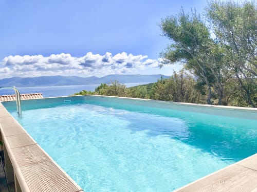 Piscine à débordement turquoise avec vue sur la mer Méditerranée aux Villas Marincelu à Porto Pollo, Corse