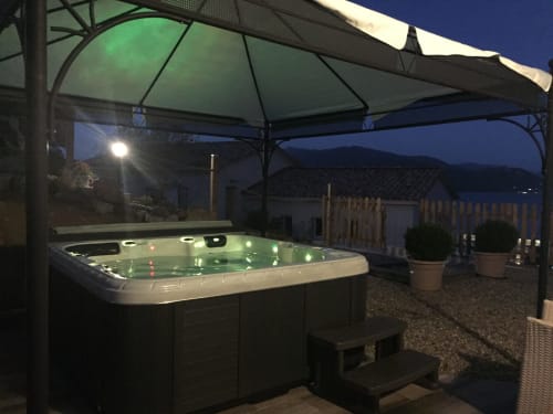 Illuminated hot tub under gazebo at Villas Marincelu, Serra di Ferro, with evening mountain views