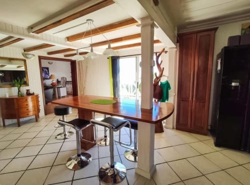 Cuisine ouverte et salle à manger aux Terrasses Du Volcan avec poutres apparentes, îlot central et vue sur la montagne