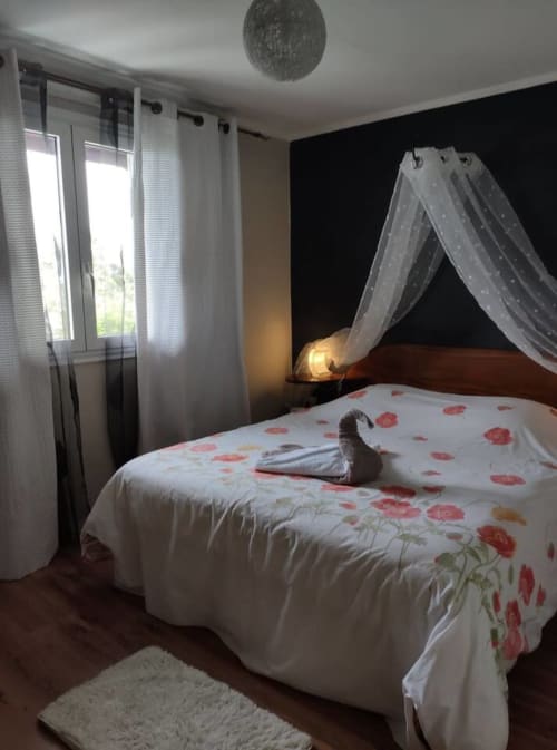 Chambre romantique aux Terrasses Du Volcan avec lit à baldaquin, parure florale rouge, vue sur la montagne et éclairage ambiant