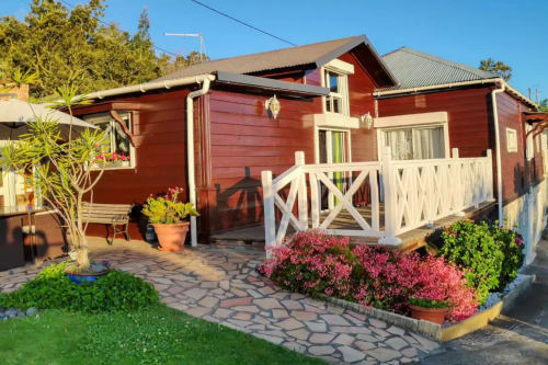 Bungalow en bois rouge avec balustrades blanches aux Terrasses Du Volcan à Tampon, Réunion