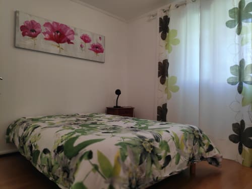 Chambre aux Terrasses Du Volcan à Tampon avec literie fleurie, tableau de fleurs roses et vue sur les montagnes