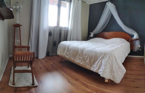 Chambre spacieuse aux Terrasses Du Volcan avec lit en bois, baldaquin blanc, parquet, fenêtres avec vue montagne