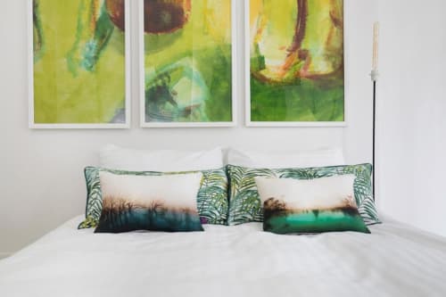 Modern bedroom at Paris B&B with white bedding, nature-themed pillows, and botanical artwork above the bed with garden view.