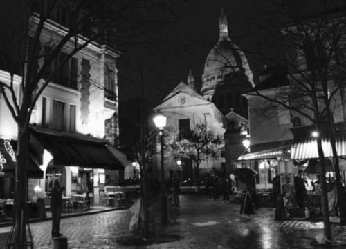Photo en noir et blanc de Paris la nuit face à la Basilic du sacré-cœur dans le quartier de Montmartre.