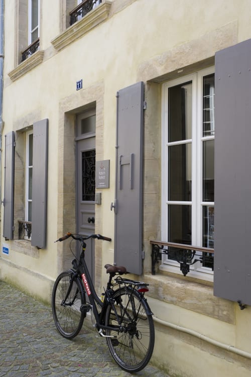 Schwarzes Fahrrad vor dem Apartment Les Filles du Bord de Mer in Port-en-Bessin, cremefarbene Fassade mit grauen Läden