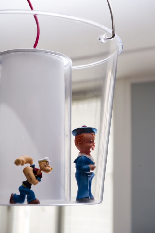Deux figurines de marins vintage dans une tasse en verre transparent aux poignées colorées aux Filles du Bord de Mer