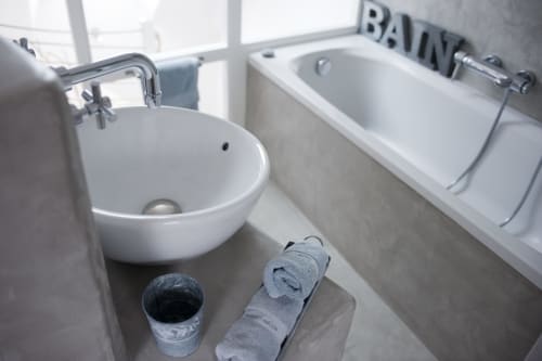 Salle de bain moderne avec lavabo rond blanc et baignoire au gîte Les Filles du Bord de Mer à Port-en-Bessin