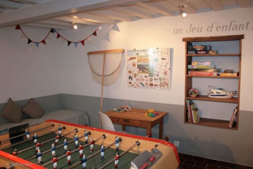 Speelkamer in het vakantiehuisje Les Filles du Bord de Mer met tafelvoetbal, boekenkast en gezellige zithoek