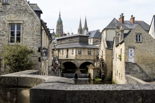 Bâtiments en pierre médiévaux et pont voûté au-dessus du moulin à eau à Port-en-Bessin-Huppain, Normandie