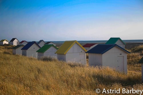 Cabines de plage colorées à Port-en-Bessin avec vue sur mer, Les Filles du Bord de Mer