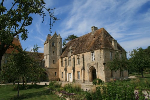Château en pierre avec tour entouré de jardins paysagés à Port-en-Bessin-Huppain, France