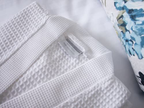 Luxury white waffle weave bathrobes with care tag at Montmartre Romantic B&B Paris garden room