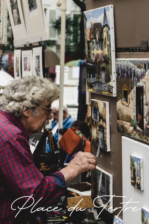 Artist displaying Parisian architectural photography at Place du Tertre market in Montmartre, Paris