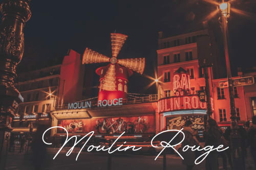 Iconic Moulin Rouge cabaret with illuminated red windmill at night, Paris Montmartre