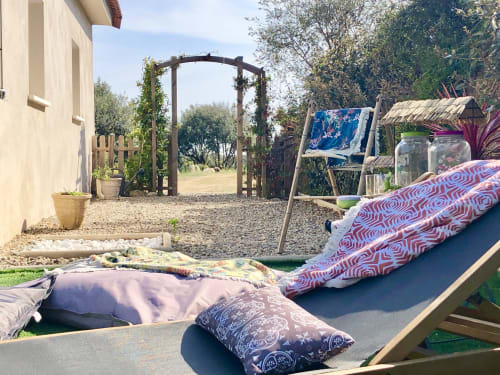 Backyard lounge area at Villas Marincelu with outdoor beds, pergola archway, and relaxation seating in Serra di Ferro