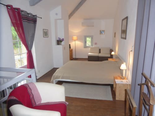Ramona cottage bedroom at Domaine de Lamartine with garden view, featuring bed, lounge area, and burgundy accents