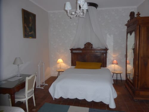Camera Antoinette al Domaine de Lamartine con letto in legno, vista sul giardino e arredamento classico