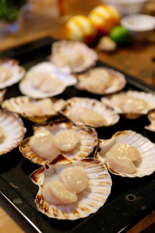 Pétoncles frais sur assiette noire aux Filles du Bord de Mer, restaurant de fruits de mer à Port-en-Bessin