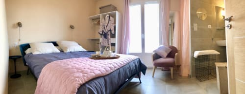 Modern bedroom at Casa Felice villa in Porto Pollo with queen bed, pink quilt, ensuite bathroom, and sea view doors