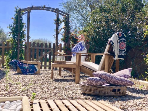 Outdoor seating area at Villas Marincelu with wooden pergola, cushioned lounge chairs, and decorative blue textiles in Porto