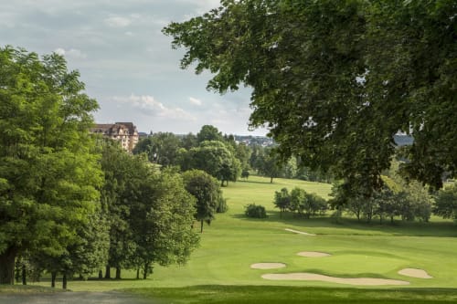 Parcours de golf à Un Air De Famille, Vittel France, avec des fairways verts impeccables entourés d'arbres